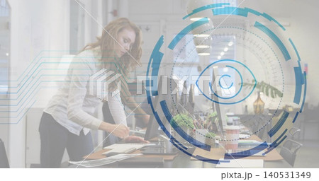 Leaning woman in light blouse, dark pants typing papers in open-plan office, HUD eye, copy space Leaning woman in light blouse, dark pants typing papers in open-plan office, HUD eye, copy space 140531349