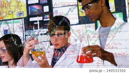 Inspecting colored beakers, four students wearing white lab coats and goggles working at school lab Inspecting colored beakers, four students wearing white lab coats and goggles working at school lab 140531502