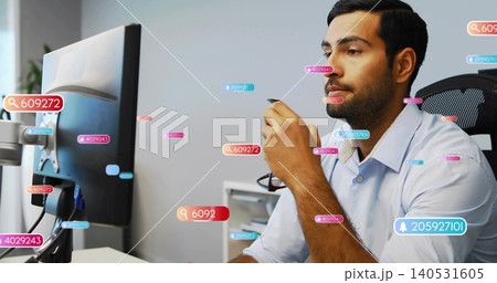 Holding eyeglasses, Asian man wearing blue shirt leaning toward monitor in office, data overlays Holding eyeglasses, Asian man wearing blue shirt leaning toward monitor in office, data overlays 140531605