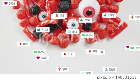 Displaying red licorice nonpareil gummies black gumdrops white eyeballs with badges on table 140531615