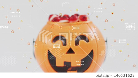 Showing orange jackolantern bucket, metal handle, black face on gray table holding red sweets, HUD 140531625