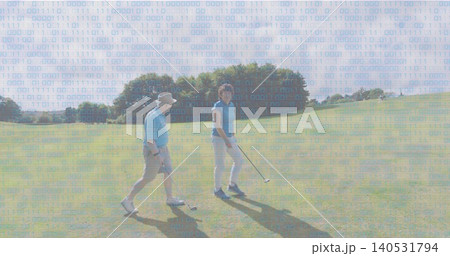 Walking senior couple wearing light-blue polos, man wearing sun hat, holding golf clubs on fairway Walking senior couple wearing light-blue polos, man wearing sun hat, holding golf clubs on fairway 140531794