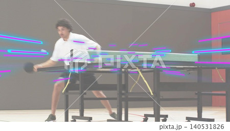 Lunging adult male in white-shirt swinging paddle toward folded table and net in gym, motion blur Lunging adult male in white-shirt swinging paddle toward folded table and net in gym, motion blur 140531826