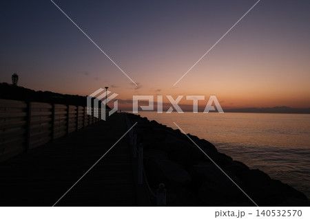 片瀬西浜海岸にて、沈みゆく太陽と夕陽を眺める人のシルエット 片瀬西浜海岸にて、沈みゆく太陽と夕陽を眺める人のシルエット 140532570
