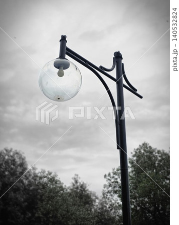 Vintage street lamp post with round glass globe against cloudy sky Vintage street lamp post with round glass globe against cloudy sky 140532824