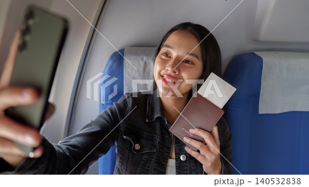 Asian woman taking selfie with passport on airplane for summer travel 140532838