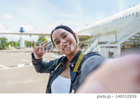 Asian woman taking selfie at airport with airplane for summer travel Asian woman taking selfie at airport with airplane for summer travel 140532839