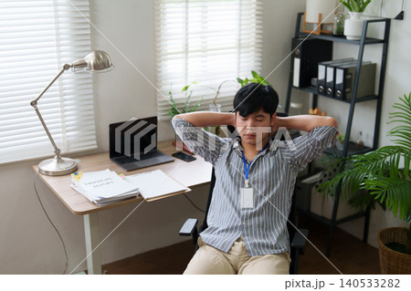 Asian man stretching and relaxing during work break at home office 140533282