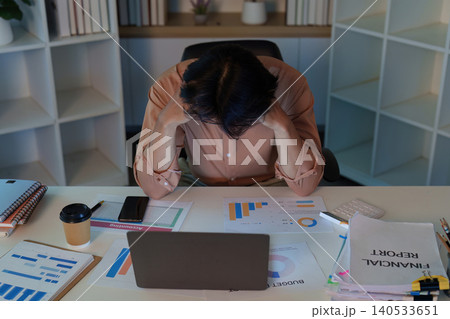 Asian man stressed by financial reports and economic slowdown at home office 140533651