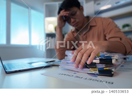 Asian man in 30s stressed by budget pie chart, economic pressure Asian man in 30s stressed by budget pie chart, economic pressure 140533653