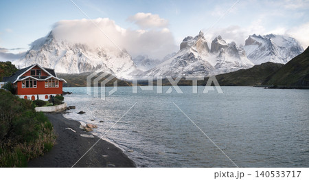 Patagonia mountain fjord with red house, snowy peak, calm water and cloudy sky Patagonia mountain fjord with red house, snowy peak, calm water and cloudy sky 140533717