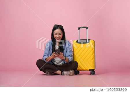 Asian woman in 20s using smartphone with suitcase, digital travel 140533809