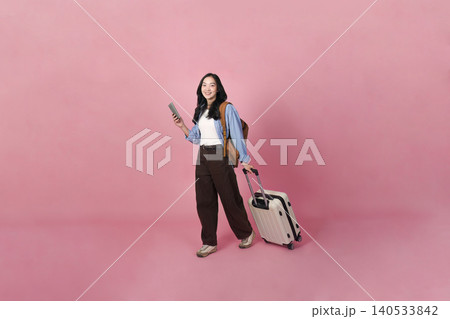 Asian woman in 20s with smartphone and luggage ready for travel 140533842
