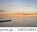 Sunset over calm sea with breakwater silhouette 140533893