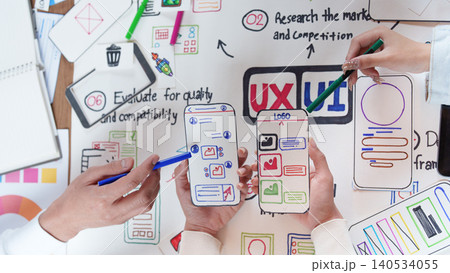 Asian design team collaborating on UX UI mobile app interface mockups Asian design team collaborating on UX UI mobile app interface mockups 140534055