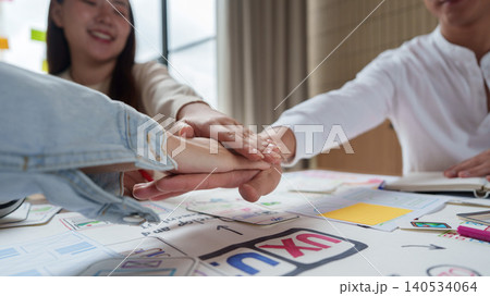 Asian business team showing teamwork and unity in office for project success. 140534064