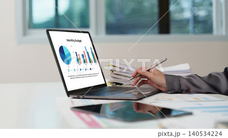 Asian woman analyzing monthly budget finance report on laptop in office Asian woman analyzing monthly budget finance report on laptop in office 140534224