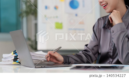 Asian businesswoman working on laptop and writing in modern office Asian businesswoman working on laptop and writing in modern office 140534227