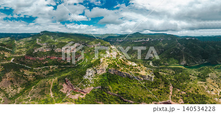 Aerial panoramic view of Siurana village perched on dramatic cliffs surrounded by rugged mountains, deep valleys and forested landscapes Aerial panoramic view of Siurana village perched on dramatic cliffs surrounded by rugged mountains, deep valleys and forested landscapes 140534228