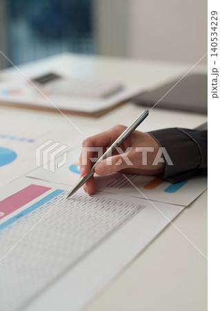 Asian woman professional doing accounting and finance writing on spreadsheet Asian woman professional doing accounting and finance writing on spreadsheet 140534229