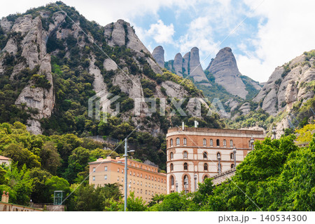 Montserrat monastery buildings beneath dramatic rocky peaks in Catalonia Spain 140534300