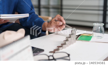 Person stacking coins for savings, investment, and financial planning. Person stacking coins for savings, investment, and financial planning. 140534381
