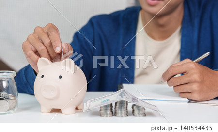 Asian man saving money in piggy bank, financial planning for future security Asian man saving money in piggy bank, financial planning for future security 140534435