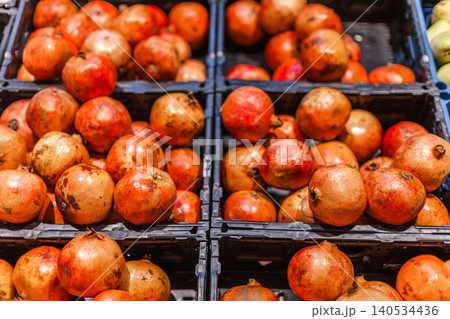 Fresh ripe pomegranates displayed in supermarket produce section for healthy grocery shopping Fresh ripe pomegranates displayed in supermarket produce section for healthy grocery shopping 140534436