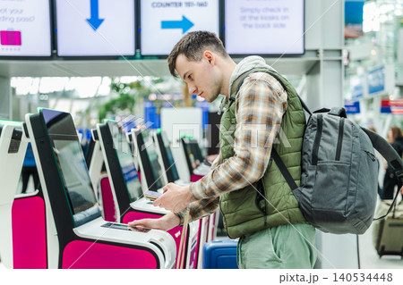 Male traveler checking flight information and completing self service airport check in with smartphone 140534448