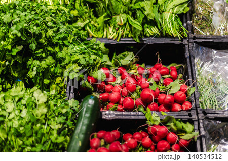 Fresh radishes and leafy greens displayed in supermarket produce section Fresh radishes and leafy greens displayed in supermarket produce section 140534512
