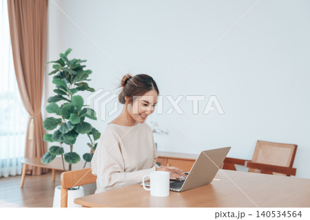 Beautiful young Asian woman working with laptop computer in living room. Work at home Beautiful young Asian woman working with laptop computer in living room. Work at home 140534564