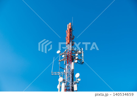 Cellular communication tower with antennas and microwave transmitters against clear blue sky, modern telecom infrastructure Cellular communication tower with antennas and microwave transmitters against clear blue sky, modern telecom infrastructure 140534659