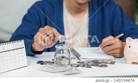 Asian man doing financial planning and budgeting with savings at home Asian man doing financial planning and budgeting with savings at home 140534674