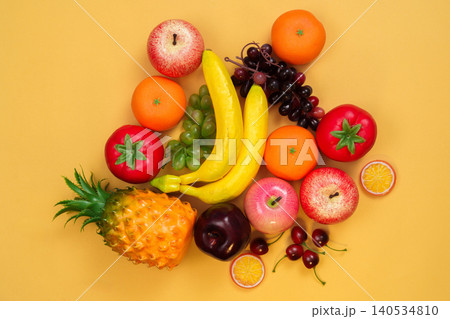 Assortment of fresh healthy fruit on vibrant yellow background Assortment of fresh healthy fruit on vibrant yellow background 140534810