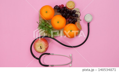 Healthy nutrition and medical care concept with fruit and stethoscope Healthy nutrition and medical care concept with fruit and stethoscope 140534871