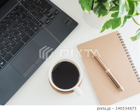 白いデスクの上のコーヒーとノートパソコン、観賞植物 白いデスクの上のコーヒーとノートパソコン、観賞植物 140534873