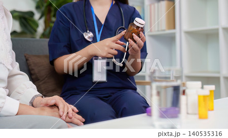 Asian caregiver explaining medicine to senior woman at home Asian caregiver explaining medicine to senior woman at home 140535316