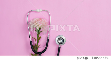 Stethoscope with pink carnation flower on vibrant background, women health 140535349