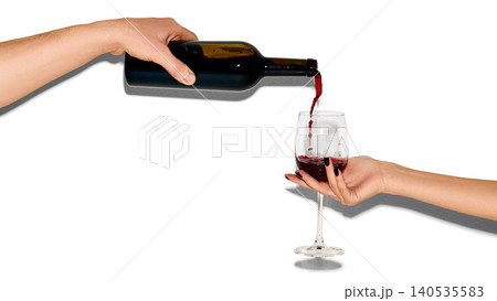 Hand pouring red wine into glass isolated on white background with copy space 140535583