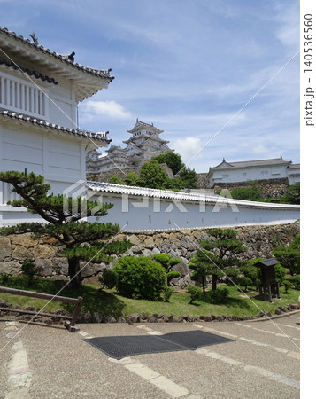 姫路城の「菱の門」の櫓と長く伸びる白壁の土塀、その奥にそびえ立つ大天守の風景 140536560