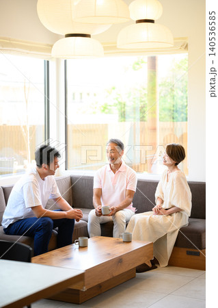 リビングで談笑する3人の人々 リビングで談笑する3人の人々 140536585