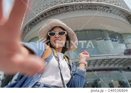 Asian woman tourist taking selfie in modern city for travel blog 140536804