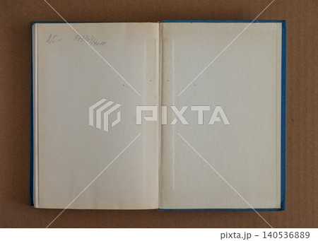 Open old book pages texture with blank aged paper, spine crease, blue cover edges, handwriting, stains. Natural background for book texture, publishing, archive, layout, mockup, design. Copy space Open old book pages texture with blank aged paper, spine crease, blue cover edges, handwriting, stains. Natural background for book texture, publishing, archive, layout, mockup, design. Copy space 140536889