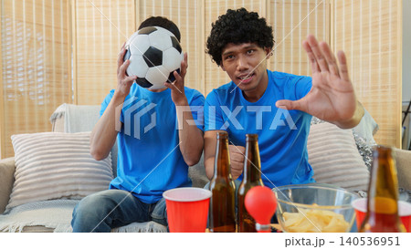 Asian and Southeast Asian men reacting with dismay to football game 140536951