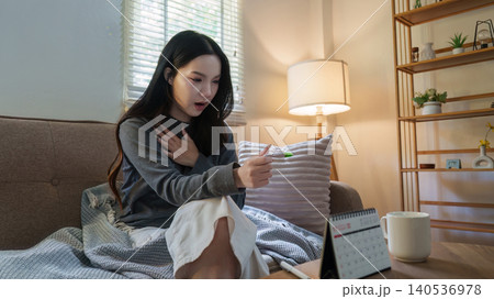 Asian woman reacting with surprise to pregnancy test result at home Asian woman reacting with surprise to pregnancy test result at home 140536978