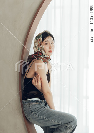 水着とデニムを合わせたスカーフを頭に巻く女性 140536999