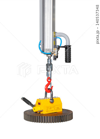 Heavy lifting equipment shows a crane with a magnetic hook and control system used in factories for moving metal parts 140537348