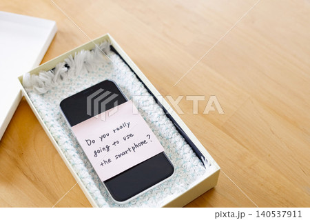 スマホを箱にしまってデジタルデトックスするイメージ素材 スマホを箱にしまってデジタルデトックスするイメージ素材 140537911