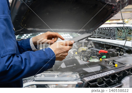 Serviceman with digital tablet on the background of the car in the car service. Serviceman with digital tablet on the background of the car in the car service. 140538022