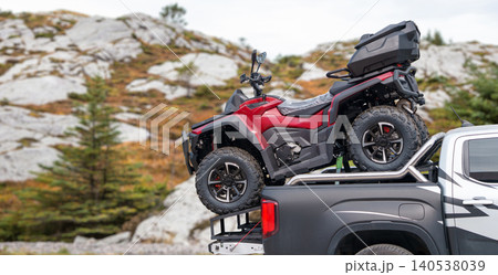 Truck with red quad bike in the trunk 140538039